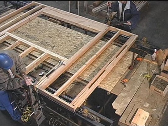 Framing wall panels at the factory in a weat controlled environment